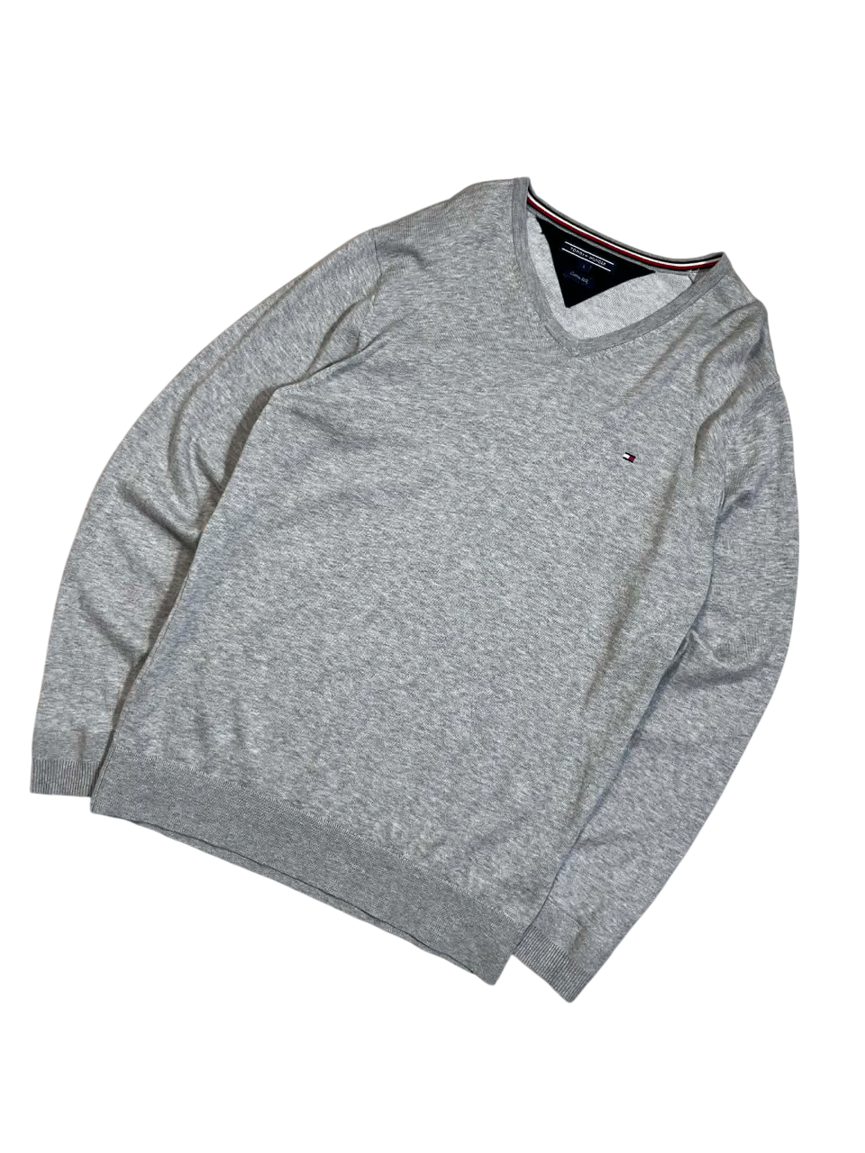 Szürke V-nyakú pulóver, hímzett logóval, vintage streetwear stílusban.