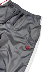 Szürke streetwear melegítőnadrág piros logóval, fehér oldalsó csíkkal