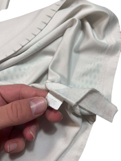 Fehér streetwear póló címkéje közelről, kézben tartva, vintage stílus