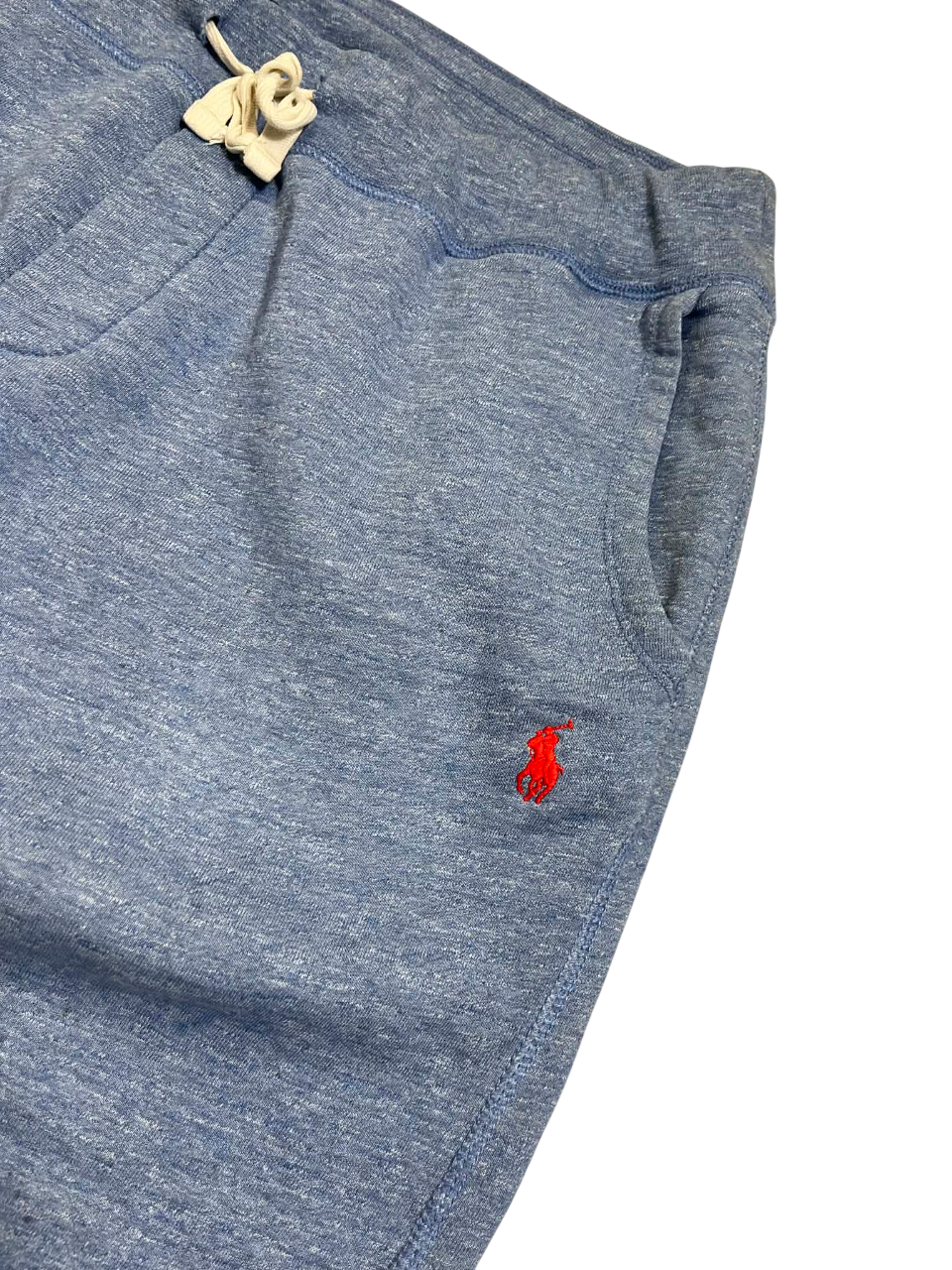 Világoskék pamut rövidnadrág zsebekkel, piros hímzett logóval, húzózsinórral.