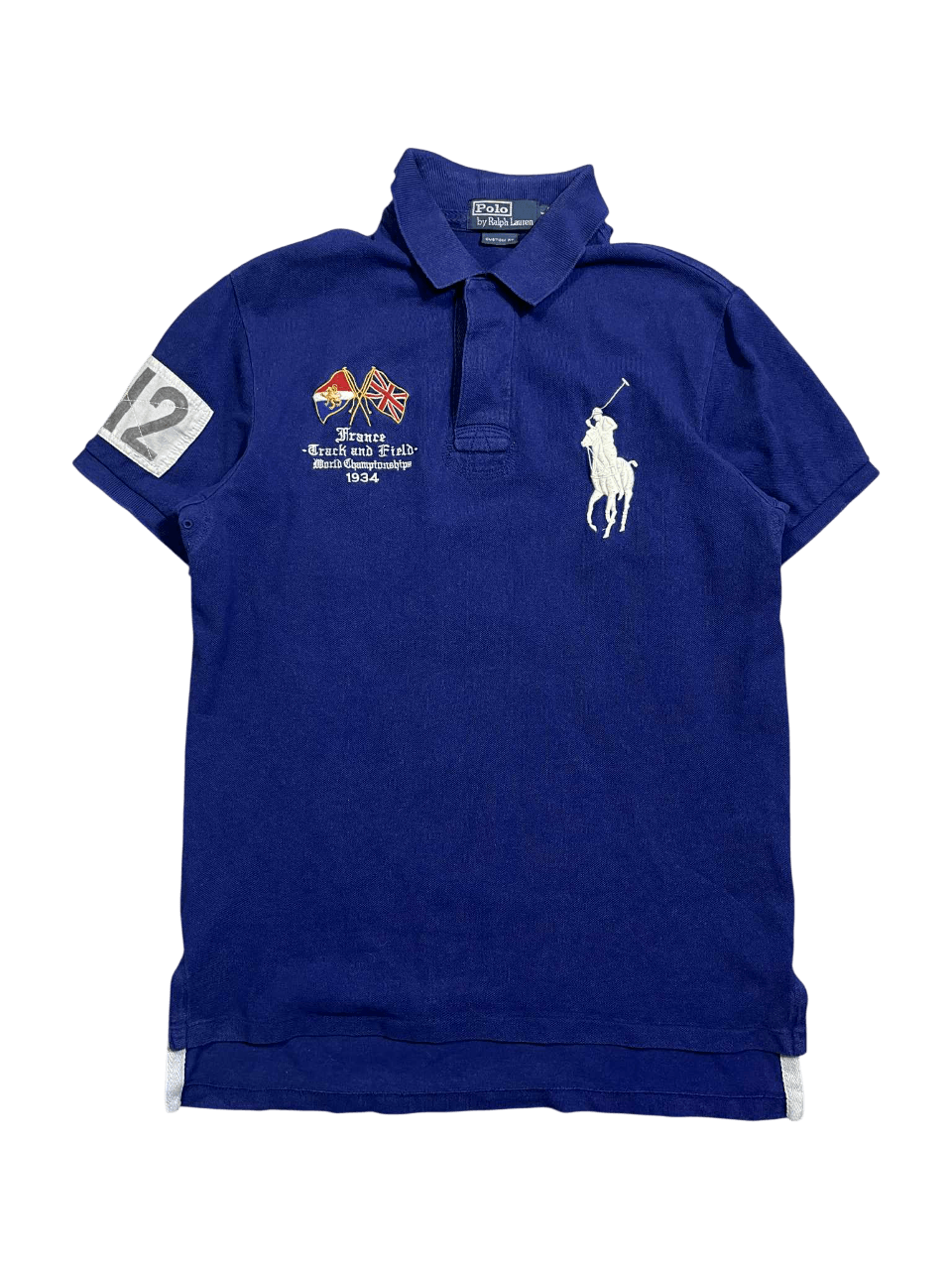 Sötétkék vintage póló gallérral, nagyméretű fehér hímzett lovas logóval, zászló és szám díszítéssel.